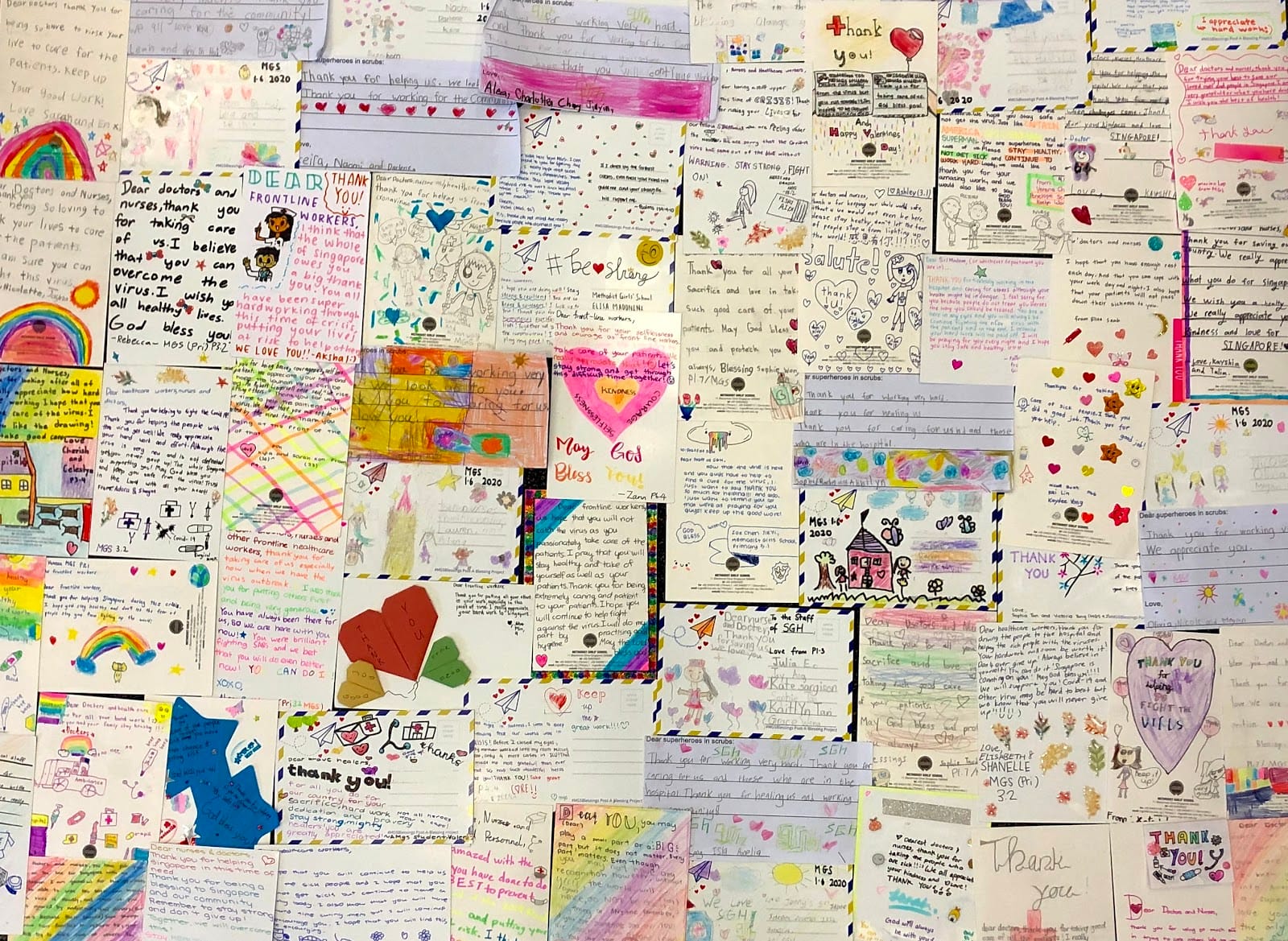 A wall covered with handwritten thank-you letters and colorful drawings from children dedicated to frontline healthcare workers.